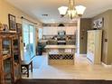Bright kitchen with white cabinets, stainless steel appliances, and a center island with wine rack at 1121 Majestic Canyon St, Henderson, NV 89052