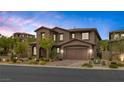 Beautiful two-story home featuring brick and stucco, mature trees, manicured landscaping, and a two-car garage at 11944 Dolcemente Ln, Las Vegas, NV 89138