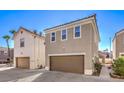 Tan home exterior featuring a two-car garage and neatly kept landscaping at 1425 Bow Creek Ct, Las Vegas, NV 89128