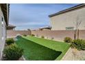 Lush backyard featuring well-maintained artificial grass, a brick perimeter and privacy wall at 1634 Deep Valley Ave, North Las Vegas, NV 89084