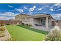 Spacious backyard with artificial turf, a covered patio, and a fully enclosed brick wall at 1634 Deep Valley Ave, North Las Vegas, NV 89084
