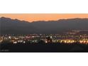 Distant city lights sparkle below mountain silhouettes at dusk at 1637 Wellington Springs Ave, Henderson, NV 89052