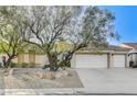 Attractive single-story home showcasing xeriscaping and a spacious three-car garage on a sunny day at 1637 Wellington Springs Ave, Henderson, NV 89052