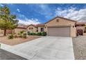 Charming single-story home has desert landscaping with a long driveway and a two car garage at 2092 Wildwood Lake Street, Henderson, NV 89052