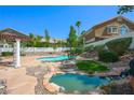 Lush backyard oasis with a sparkling pool, rock features, and mature landscaping, ideal for outdoor entertaining at 2097 Eaglepath Cir, Henderson, NV 89074