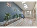 Bright entryway with skylights, wood-look flooring, a decorative planter and a modern front door at 2129 N Michael Way, Las Vegas, NV 89108