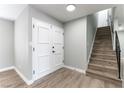 Bright entryway featuring modern wood-look floors, a staircase, and a white paneled front door at 2346 Roan Ave, Las Vegas, NV 89119