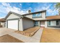 View of a two-story home featuring a well-maintained exterior, a stone-lined flower bed, and a paved walkway to the front door at 2346 Roan Ave, Las Vegas, NV 89119
