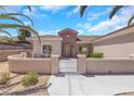 Inviting front exterior featuring a gated entrance, manicured landscaping, stucco walls, and a tile roof at 2349 Orangeburg Pl, Henderson, NV 89044