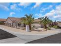 Charming single-story home featuring desert landscaping with two palm trees, a beige exterior, and a tiled roof at 2349 Orangeburg Pl, Henderson, NV 89044