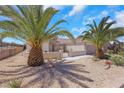 Beautiful home featuring desert landscaping, a private gate, and mature palm trees at 2349 Orangeburg Pl, Henderson, NV 89044