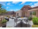 Relaxing outdoor patio with a dining table, seating, and lush greenery, perfect for entertaining and enjoying the weather at 2349 Orangeburg Pl, Henderson, NV 89044