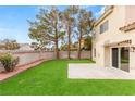 Well-maintained backyard with green lawn, mature trees, and concrete patio, perfect for outdoor entertaining at 3709 Misty Falls St, Las Vegas, NV 89129