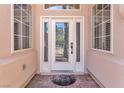 Close up of a front door with decorative glass, sidelights, and transom window providing ample natural light at 465 Indigo Springs St, Henderson, NV 89014