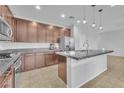 Modern kitchen with granite countertops, stainless steel appliances, and sleek brown cabinetry at 5731 Sedona Springs St, North Las Vegas, NV 89031