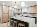 Modern kitchen with stainless steel appliances, a large island, and stylish pendant lighting above the island at 5840 N El Capitan Way, Las Vegas, NV 89149