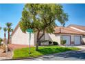 Attractive property with a tile roof, green lawn, mature tree, and single-car garage at 653 Mountain Rdg, Mesquite, NV 89027