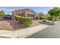 Well-manicured front yard and driveway of this house leading up to the three-car garage at 7340 Orchard Harvest Ave, Las Vegas, NV 89131