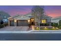 Beautiful single-story home with a three-car garage featuring outdoor lighting at 7340 Orchard Harvest Ave, Las Vegas, NV 89131