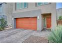 Close up of a modern home showcasing a two-car garage, a welcoming front door and beautiful hardscape at 8087 Carpenter Creek Ave, Las Vegas, NV 89113