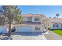 Charming stucco home featuring a red tile roof, arched entryway, and a spacious two-car garage at 8753 Fountain Island Dr, Las Vegas, NV 89147