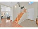Bright foyer featuring hardwood floors, a staircase with wood banister, and a tiled entrance at 9009 Ochoa St, Las Vegas, NV 89143