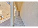 Inviting covered entrance with a neutral color palette, showcasing a tiled walkway leading to the front door at 9198 Rolling Sky Dr, Las Vegas, NV 89178