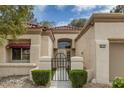 Charming front entrance with a tiled roof, an arched window and courtyard gate at 9437 January Dr, Las Vegas, NV 89134