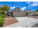 Inviting two-story home featuring a three-car garage, well-manicured landscaping, and a charming exterior at 955 Leadville Meadows Dr, Henderson, NV 89052
