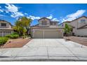 Beautifully landscaped two-story home with a spacious driveway, three-car garage, and well-maintained lawn at 955 Leadville Meadows Dr, Henderson, NV 89052