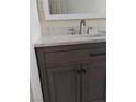 Modern bathroom vanity with gray wood cabinets, stylish hardware, white marble countertop, and a framed mirror at , North Las Vegas, NV 89030
