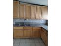 Traditional kitchen with tan cabinetry, granite countertops, a mosaic backsplash, and stainless steel sink at , North Las Vegas, NV 89030