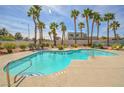 Relaxing community pool surrounded by swaying palm trees and comfortable lounge chairs for residents at 1000 Grammy Dr, Las Vegas, NV 89145