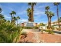 Welcoming entrance to Stone Canyon Northwest, surrounded by lush palm trees and desert landscaping at 1000 Grammy Dr, Las Vegas, NV 89145