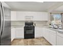 Bright kitchen with stainless steel refrigerator, white cabinets and tile flooring at 10324 Lettuce Leaf St, Las Vegas, NV 89183