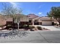 Charming single-story home with a tile roof, desert landscaping, and a spacious three-car garage at 1963 Dakota Lodge Ave, Las Vegas, NV 89123