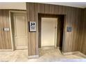 Wood-paneled hallway featuring a well-maintained elevator with nearby stairwell and trash disposal at 20 E Serene Ave # 111, Las Vegas, NV 89123