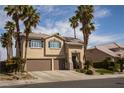 Two-story home with desert landscaping including shrubs and towering palm trees at 2544 Sundew Ave, Henderson, NV 89052