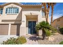 Double front doors with wreaths, desert landscaping, and two car garage at 2544 Sundew Ave, Henderson, NV 89052
