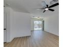 Bright living room with wood floors, a ceiling fan and sliding glass doors leading to the backyard at 3040 Carroll St, North Las Vegas, NV 89030