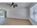 Bright living room featuring wood floors, a ceiling fan, and a large window for ample natural light at 3040 Carroll St, North Las Vegas, NV 89030