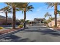 Gated community entrance with mature palm trees and meticulously maintained landscaping at 3934 Sangre De Cristo Ave, Las Vegas, NV 89118