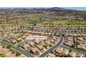 Community aerial view showcasing homes, golf course and the mountains at 435 Piute Valley Ct, Henderson, NV 89012