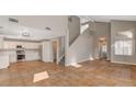 Open-concept living space with tile floors, neutral walls and staircase to second floor at 4411 Wild Honey Ct, Las Vegas, NV 89147