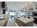 Bright kitchen with modern appliances, an island with bar seating, and pendant lighting fixtures at 600 Quail Covey Road, Henderson, NV 89002