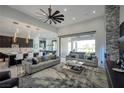 Open-concept living room showcasing modern decor, a large fan, and sliding doors to the patio at 600 Quail Covey Road, Henderson, NV 89002