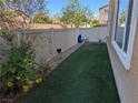 Fenced backyard with green grass and exterior wall at 7057 Millers Run St, North Las Vegas, NV 89084