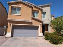 Two-story home featuring a grey garage door, brick driveway, and desert landscaping at 7057 Millers Run St, North Las Vegas, NV 89084