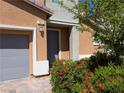 Close up of front door and landscaping, showing brick pavers, exterior lighting and a tidy garden at 7057 Millers Run St, North Las Vegas, NV 89084