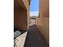 Side yard featuring brick pavers and white vinyl fencing to create a private outdoor space at 7057 Millers Run St, North Las Vegas, NV 89084